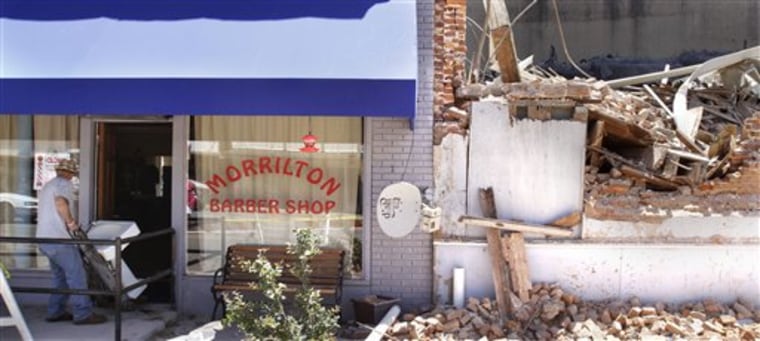 A man removes a sink from a barber shop next to a collapsed building in Morrilton, Ark., Tuesday, May 17, 2011. The building fell Monday killing a child and injuring several other people. (AP Photo/Danny Johnston)